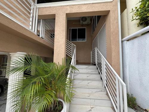 a stairway leading to a building with a palm tree at 360 Rokview Suites Cozy 1BR Private Suite in Kupuis