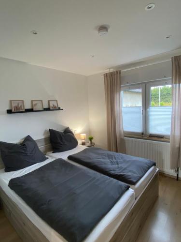 a bedroom with two beds and a window at Kleines WaldGlück Wennemen in Meschede