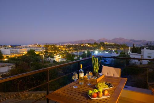 a table with wine glasses and fruit on a balcony at Ormos senses in Agios Nikolaos