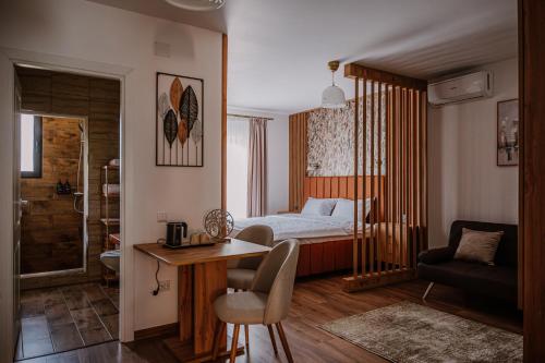a hotel room with a bed and a desk and a bedroom at La Pădure 