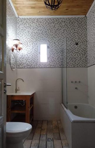 a bathroom with a toilet and a tub and a sink at hospedaje cerro nevado in El Nihuil