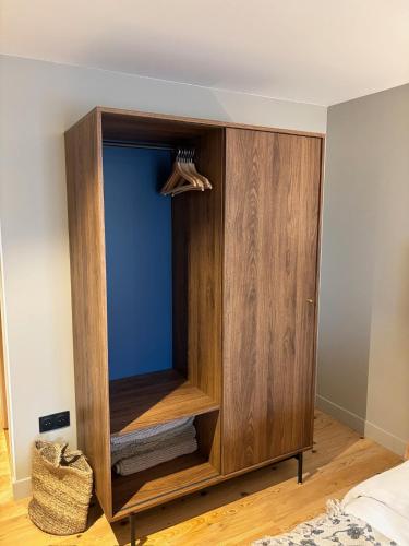 a wooden cabinet with a tv in a bedroom at Les chambres de la Villa Oberlin in Beblenheim