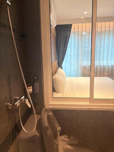 バンコクにあるApartment in Central Sukhumvitの窓付きのバスルーム(ベッド付)