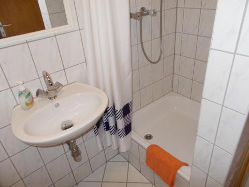 a white bathroom with a sink and a shower at Hotel am Freihafen in Duisburg