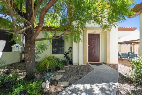 a house with a tree and a walkway at Elm Casita Apts in Litchfield Park