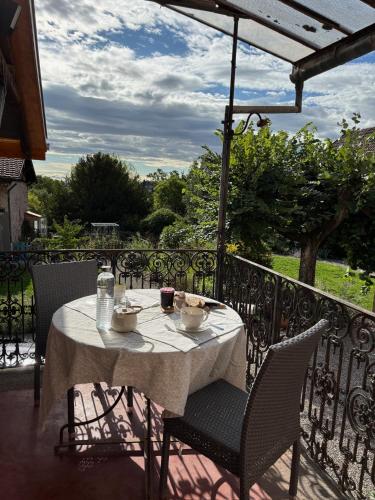 a table with a white table cloth on a balcony at Les chambres de la Villa Oberlin in Beblenheim