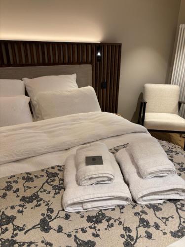 a bed with towels and a tablet on top of it at Les chambres de la Villa Oberlin in Beblenheim
