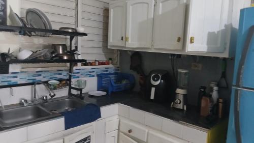 a kitchen with white cabinets and a sink at Recycled house in Santo Domingo
