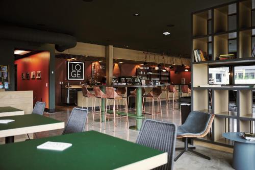 ミズーラにあるLOGE Missoulaのテーブルと椅子とバーのあるレストラン