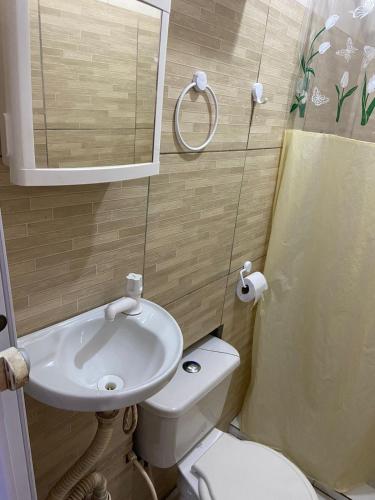 a small bathroom with a sink and a toilet at Casa em frente a praia - Ilha dos Frades in Salvador