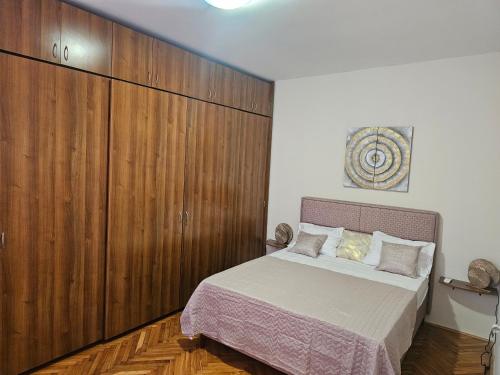 a bedroom with a bed and a large wooden cabinet at Apartment K8 Center in Podgorica