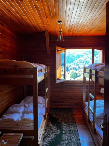 zwei Etagenbetten in einem Zimmer mit Fenster in der Unterkunft Chalet La Ponote in Samoëns