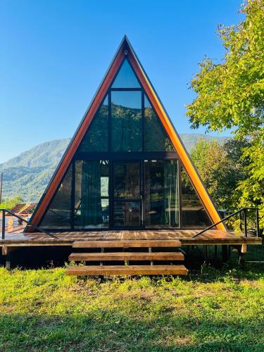 a house with a triangle roof on a field at Rachuli blendi in Ambrolauri