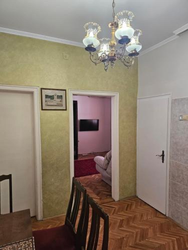 a dining room with a chandelier and a table and chairs at Apartment K8 Center in Podgorica