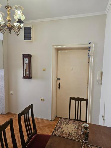 a dining room with a table and chairs and a door at Apartment K8 Center in Podgorica