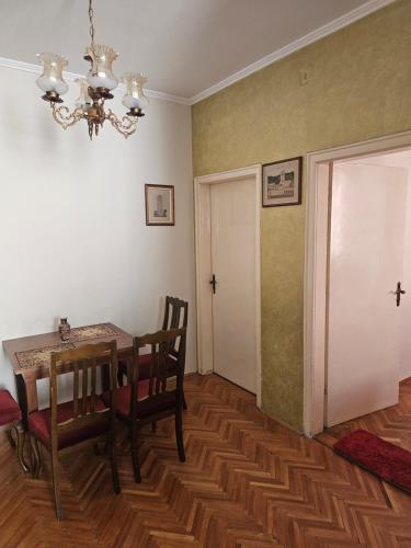a dining room with a table and chairs and a chandelier at Apartment K8 Center in Podgorica