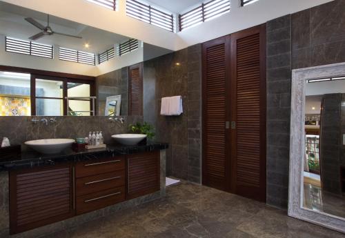 a bathroom with two sinks and a large mirror at Villa Zamaya Sanur in Sanur