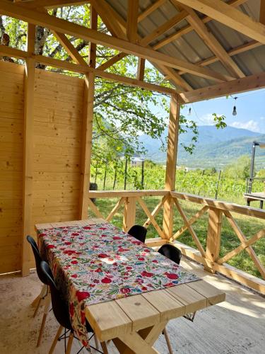 a wooden table in a pavilion with a tablecloth on it at Rachuli blendi in Ambrolauri