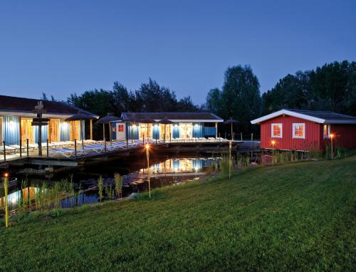 a row of houses with lights on a river at WONNEMAR Resort-Hotel in Wismar