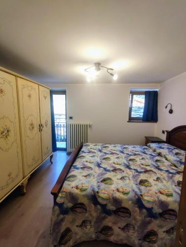 a bedroom with a bed with a floral bedspread at Appartamento Alta Valle Maira 