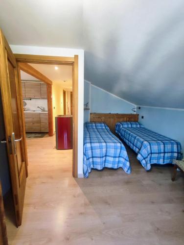 two beds in a room with a door open at Appartamento Alta Valle Maira 