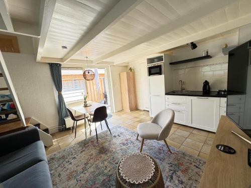 a kitchen and living room with a table and chairs at Balsemientexel in De Koog
