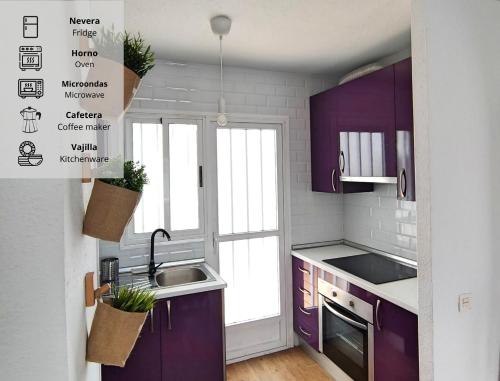 eine Küche mit lila Schränken, einem Waschbecken und einem Fenster in der Unterkunft La Casita de Vera in Playas de Vera