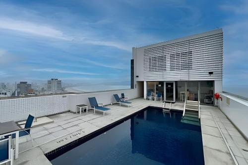 uma piscina no telhado de um prédio em Suíte em flat no Gonzaga Stay Helbor em Santos