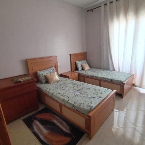 a room with two beds and a window at Maison d'hôte Najah 2 in Khenifra