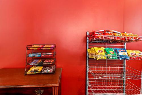 a wire rack with chips and snacks on a red wall at Red Roof Inn Yuba City Bonanza - Marysville in Yuba City