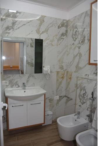 a bathroom with a sink and a mirror at Guest House Nuhellari in Çorovodë