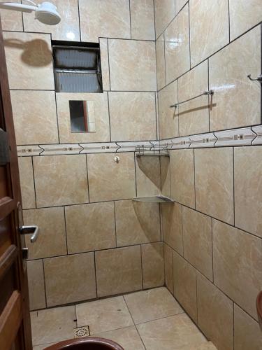 多拉杜斯Casa Parque Alvorada com garagem e ar Condicionado的一间带淋浴的浴室和瓷砖墙