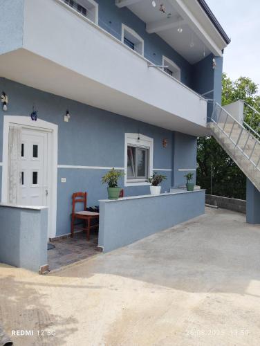 a blue house with a staircase and a patio at Vila Marini in Lin