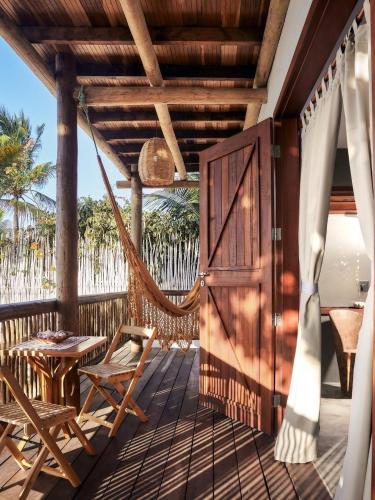 a porch with a hammock and a swing at Pousada Villa Tibá in Jericoacoara