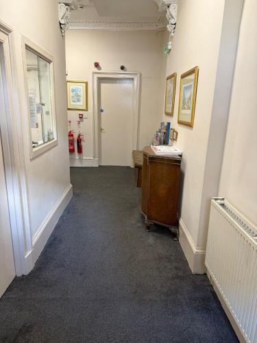 a hallway with a room with a desk and a fire hydrant at Glasgow House in Glasgow