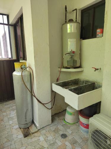 a kitchen with a sink and a water tank at Departamento Familiar Escorpións in Tuxtla Gutiérrez
