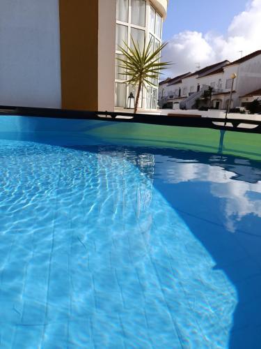 a swimming pool with blue water in front of a building at Bal&Bal in Ferrel