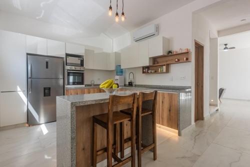 a kitchen with a counter and a refrigerator at Malibu Residential 3BD - Tael in Cozumel