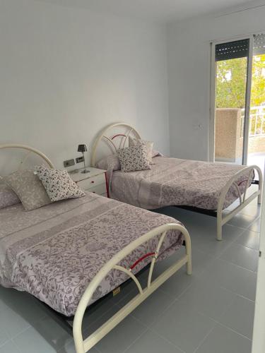 a bedroom with two beds and a window at Residencial Aguilas Playa in Águilas