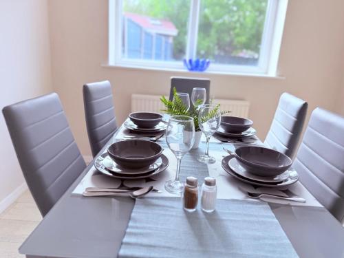 a table with plates and wine glasses on it at Spacious 3-Bed Contractor-Friendly Home in Bristol