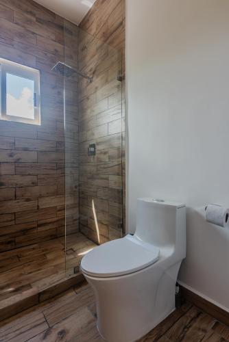 a bathroom with a toilet and a shower at Malibu Residential 3BD - Tael in Cozumel