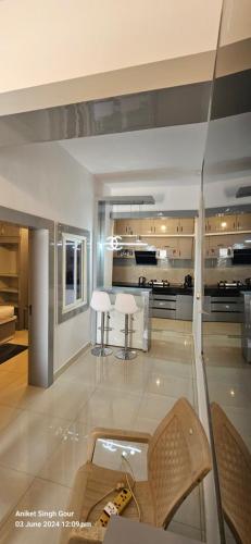 a living room with a table and chairs and a kitchen at Hotel Sunset in Orchha