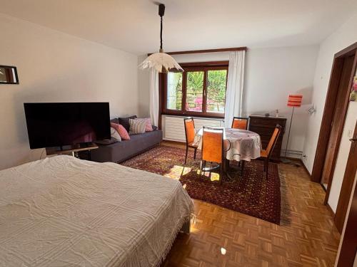a bedroom with a bed and a table and a couch at Les Biches in Corminboeuf
