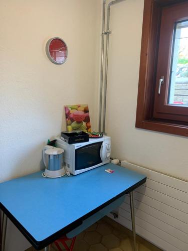 a blue table with a microwave on top of it at Les Biches in Corminboeuf