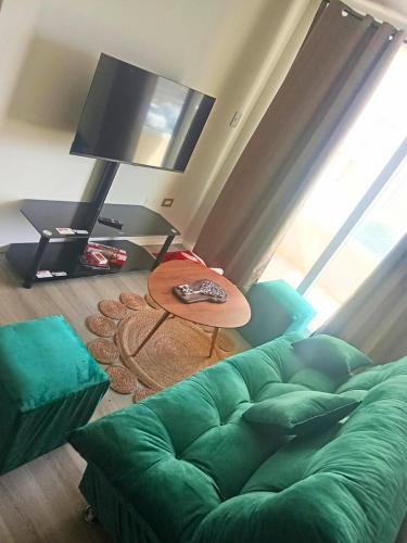 un salon avec un canapé vert et une table dans l'établissement Departamento La serena, à La Serena