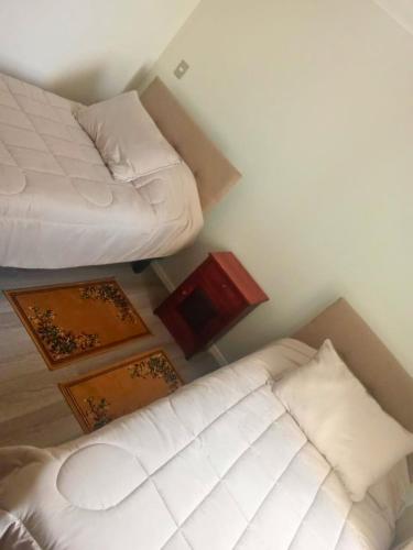 Cette chambre comprend deux lits, une table et un lit. dans l'établissement Departamento La serena, à La Serena