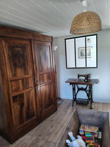 a room with a wooden door and a table at La Maison des Rosiers in Manhac