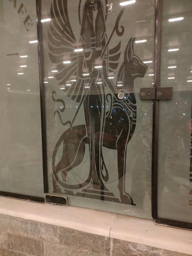 a window with a painting of a woman and a deer at Komaty pyramids view in Cairo