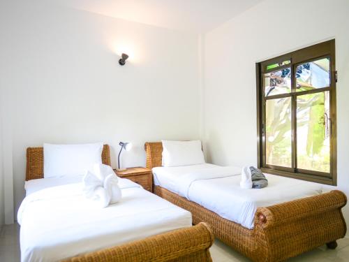 ein Zimmer mit zwei Betten und einem Fenster in der Unterkunft Gaia Garden in Ban Mai