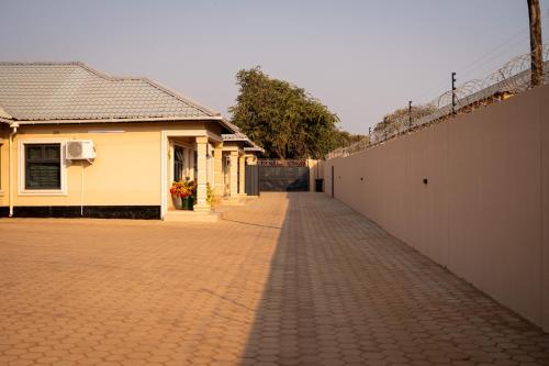 a brick road next to a building and a fence at RJV Apartments, Meanwood Ibex Hill, Lusaka in Lusaka